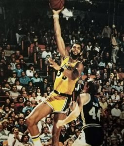 Kareem Abdul-Jabbar, who won five NBA titles withe LA Lakers during the 1980s, hoists his patented skyhook off Denver Nuggets' Dan Issel.