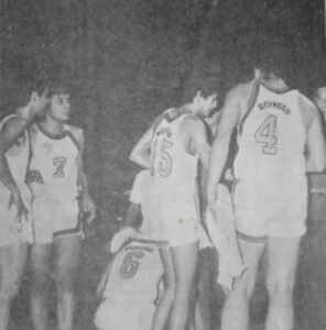 Stars of the 1971 Meralco team huddle around coach Lauro Mumar.
