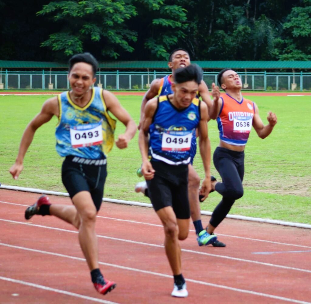 Jaymark Balicha (left) is poised to surge past teammate Richard Caralipio on the way to victory in the men’s 200-meter run in the men’s Army division of the ROTC Games Luzon leg at the Cavite State University [PSC photo]