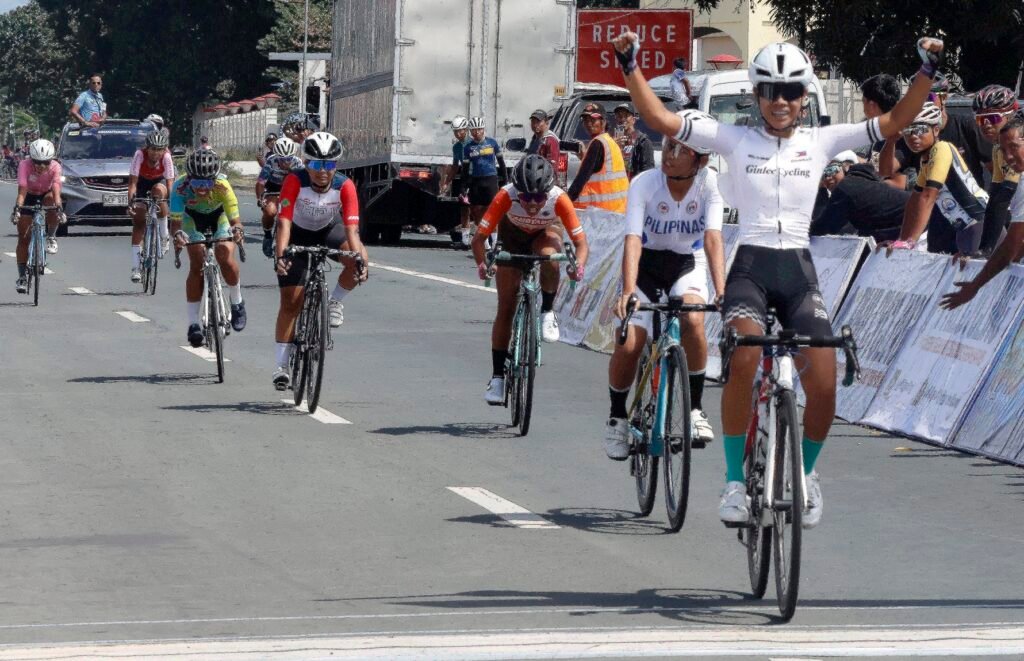 Jazmine Kaye Vinoya raises her hands in triumph after winning the Women Junior road race.