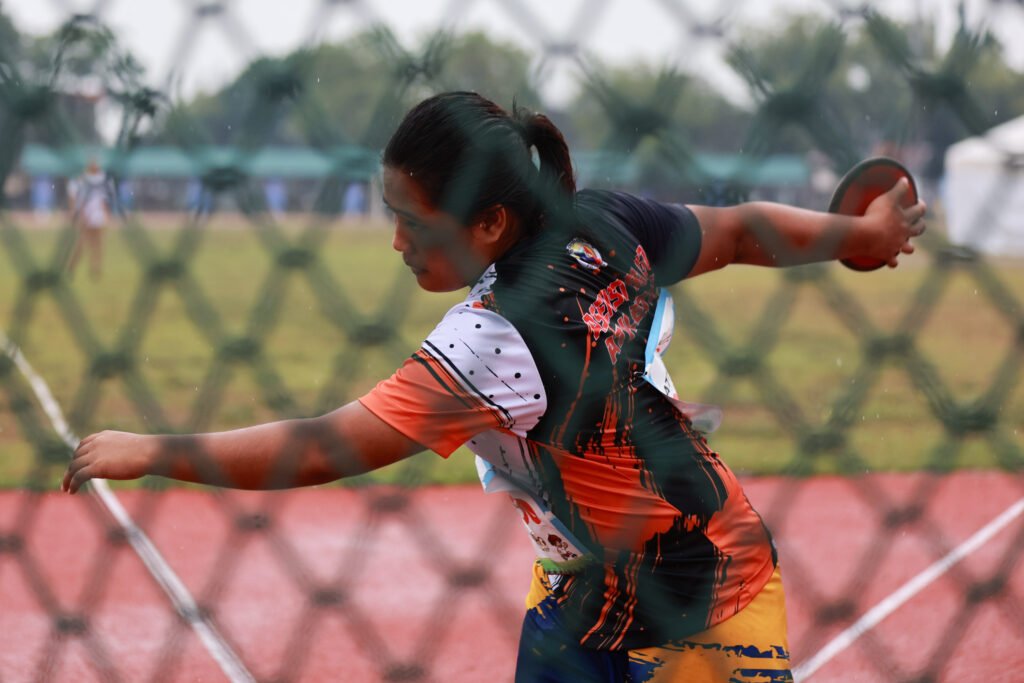 Bago City’s Divine Pablito competes in the girls’ discus throw under rainy conditions. [PR photo]